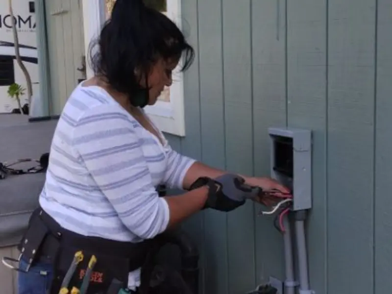 Licensed electrician wiring an exterior subpanel in Green